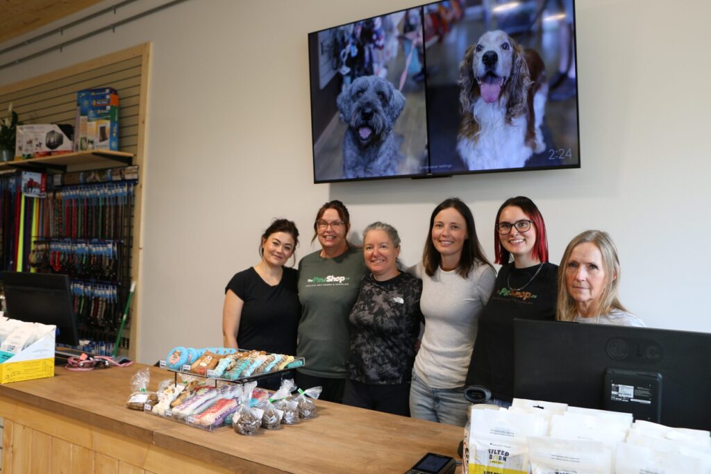 The Paw Shop staff team photographed together at the front counter of the new store