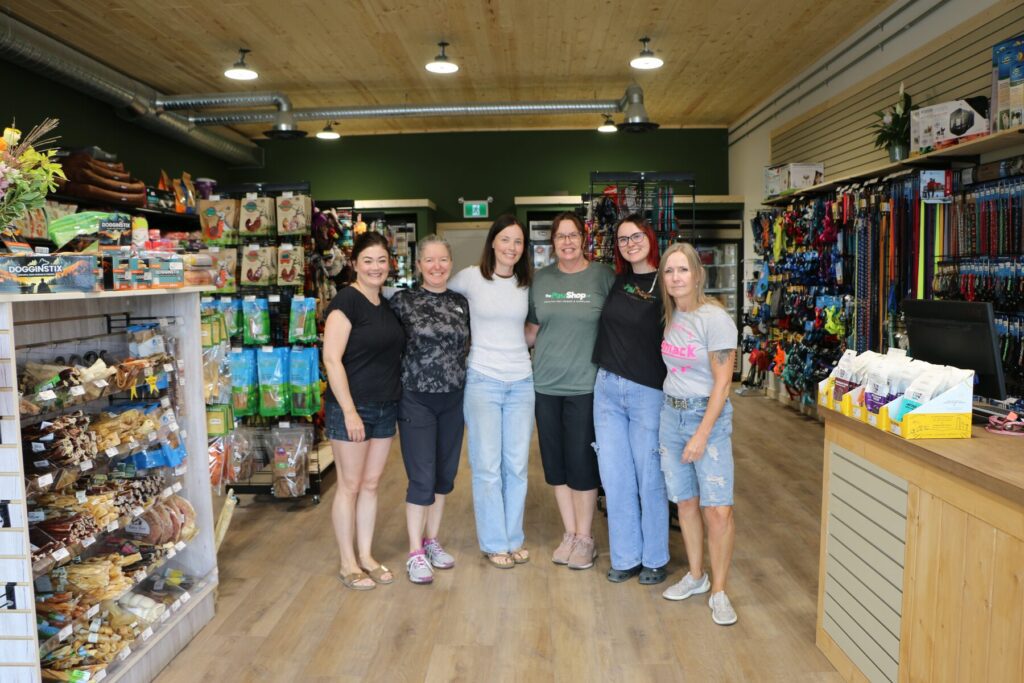The Paw Shop team standing together in the aisles of the new downtown Cranbrook store